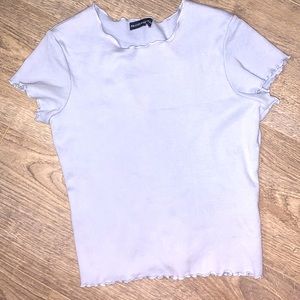 A blue plain shirt with ruffles on the sleeves.